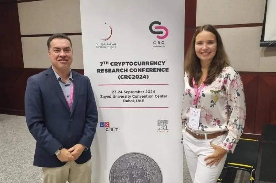 Dos personas en conferencia de criptomonedas en Zayed University Dubai.